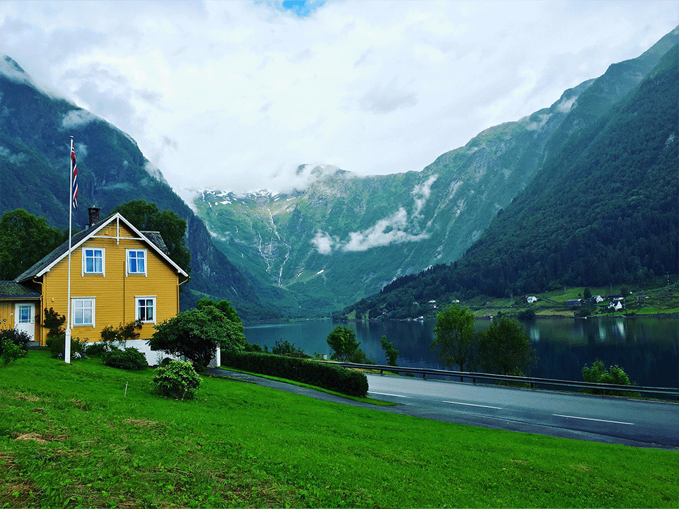 hus i dal med norsk flagg